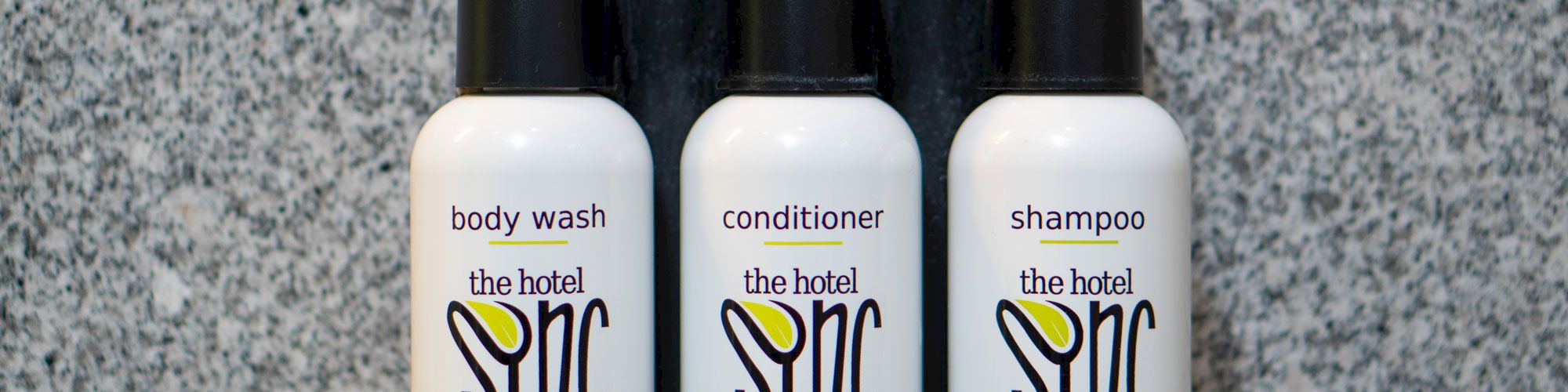 The image shows three mounted bottles labeled for body wash, conditioner, and shampoo from 