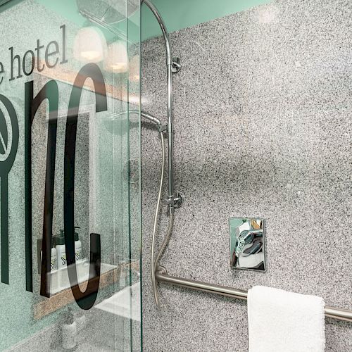 The image shows a modern bathroom with a glass shower door labeled 